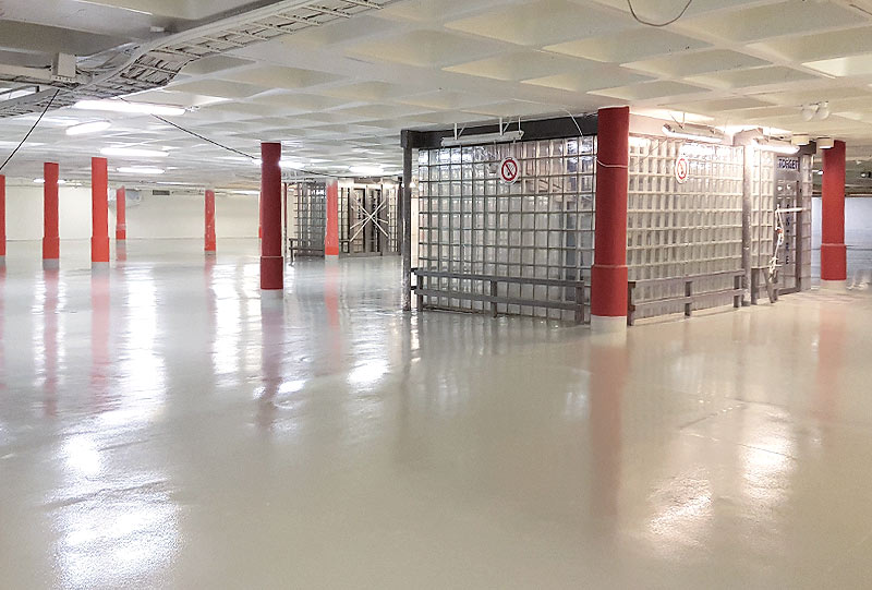 ytbehandlat golv och röda pelare i en lokal